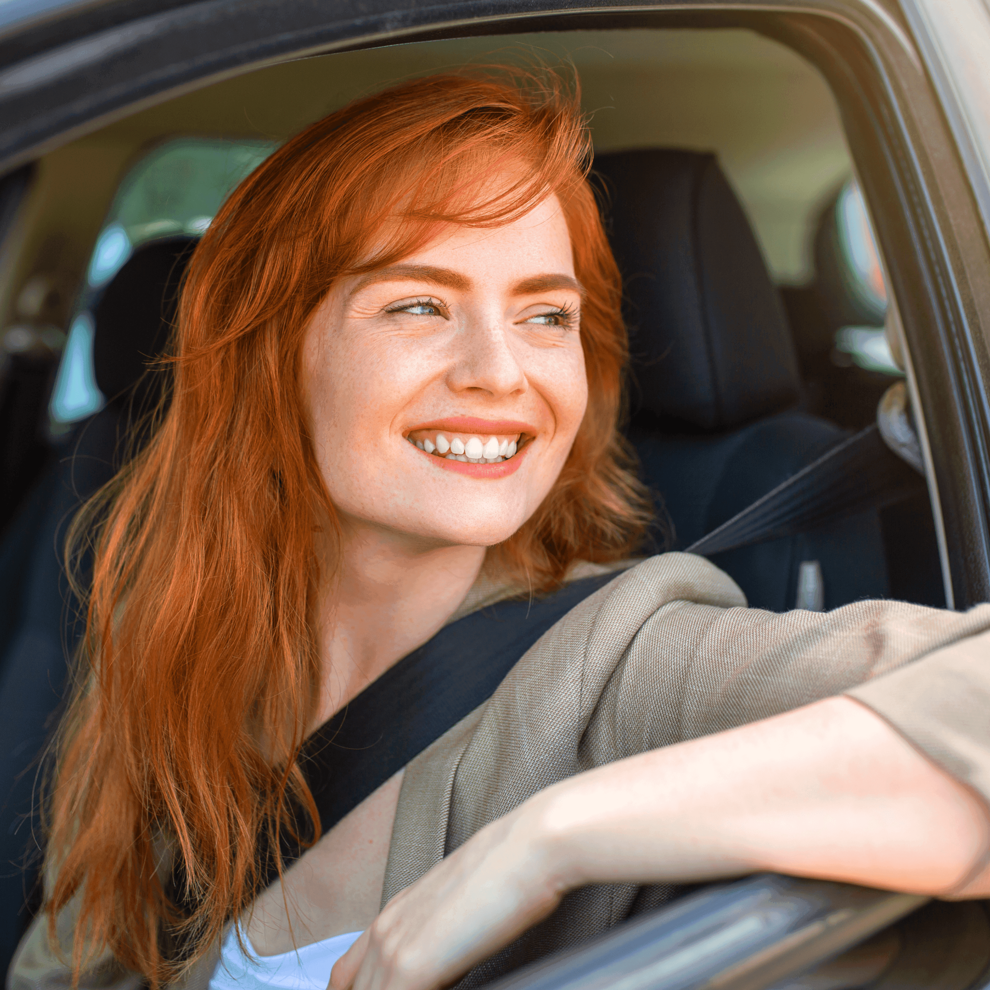 Uśmiechnięta kobieta w samochodzie.